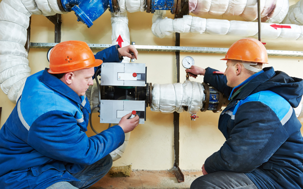 Hvac Technicians Looking At Heating System In Boiler Room