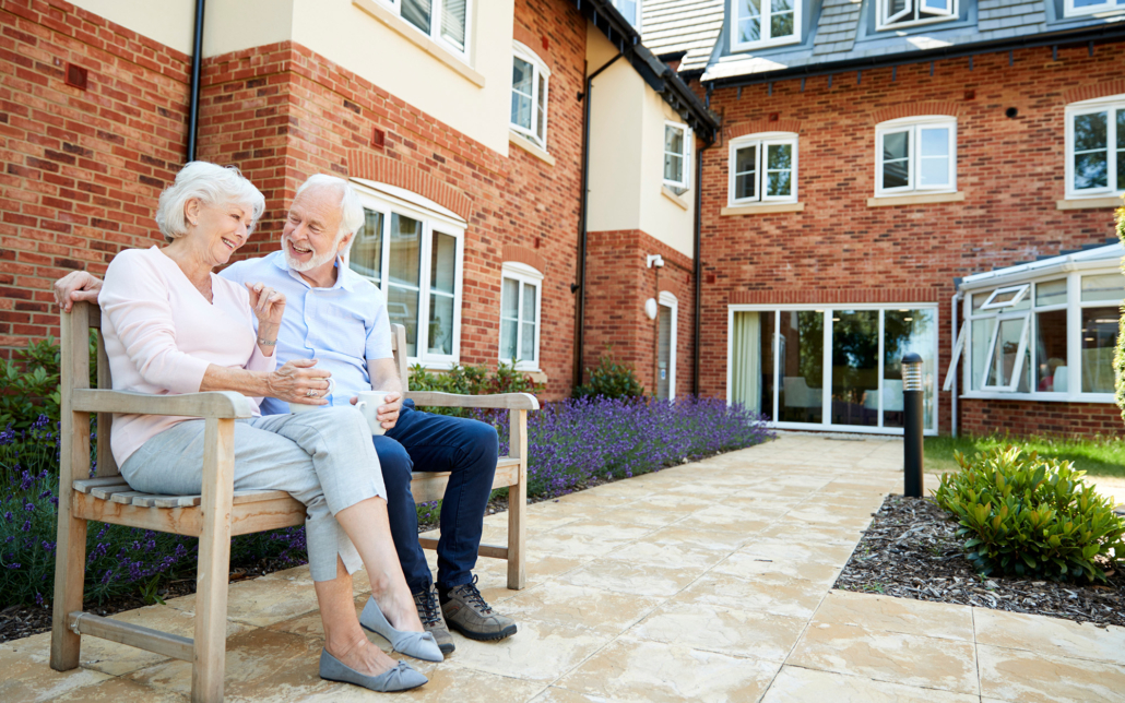 Senior Couple On Assisted Living Facility Bench