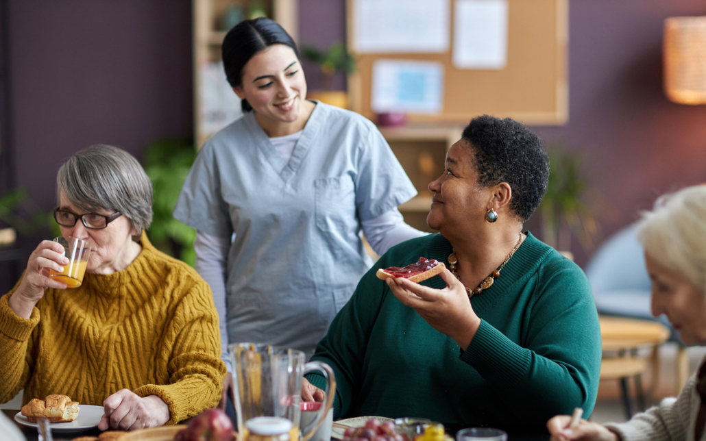 Smiling Caregiver Checking On Senior Patients